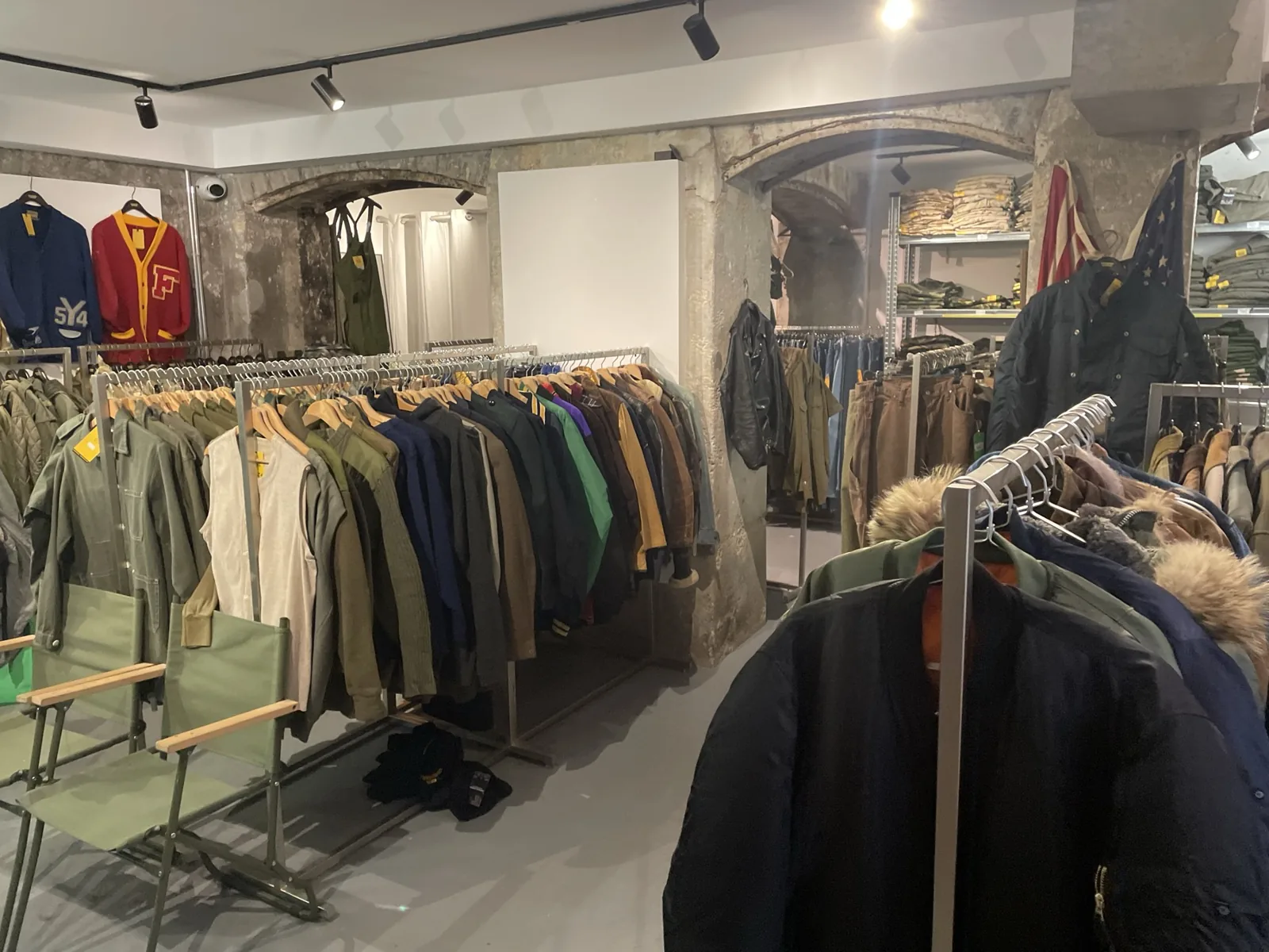 シャツやジャケットがラックに並ぶ服屋の店内