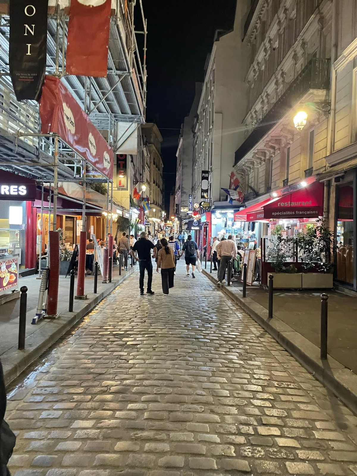 店の明かりが続く夜の石畳の通り